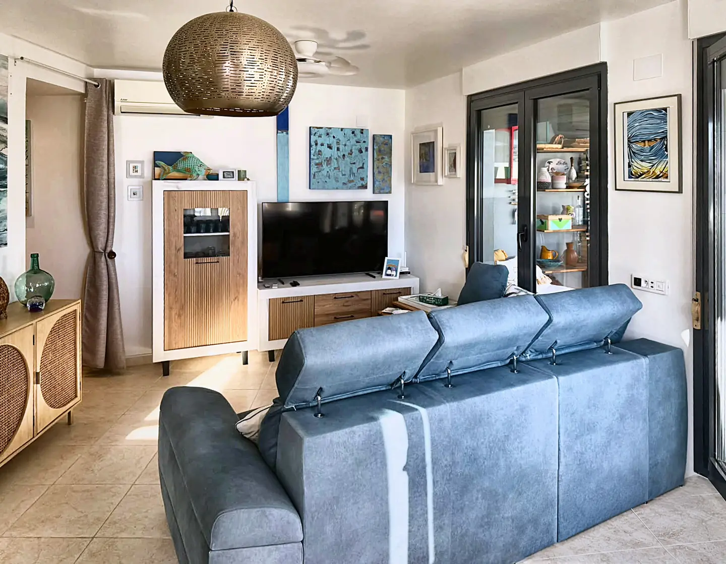 Salón de Sotavento con sofá azul y muebles de madera.
