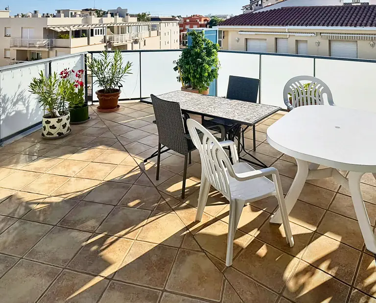 Terraza de Sotavento con mesas y plantas.