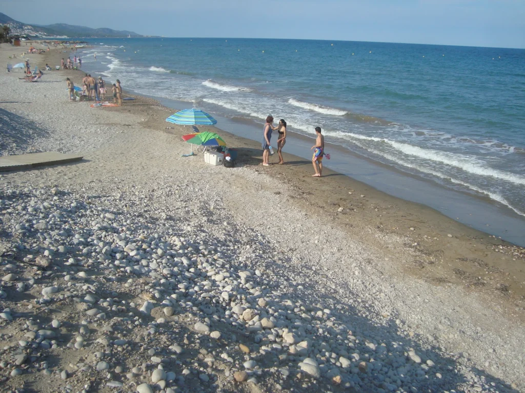 Orilla de Playa Tropicana o Manyetes en Alcossebre, con arena, cantos rodados y el mar Mediterráneo