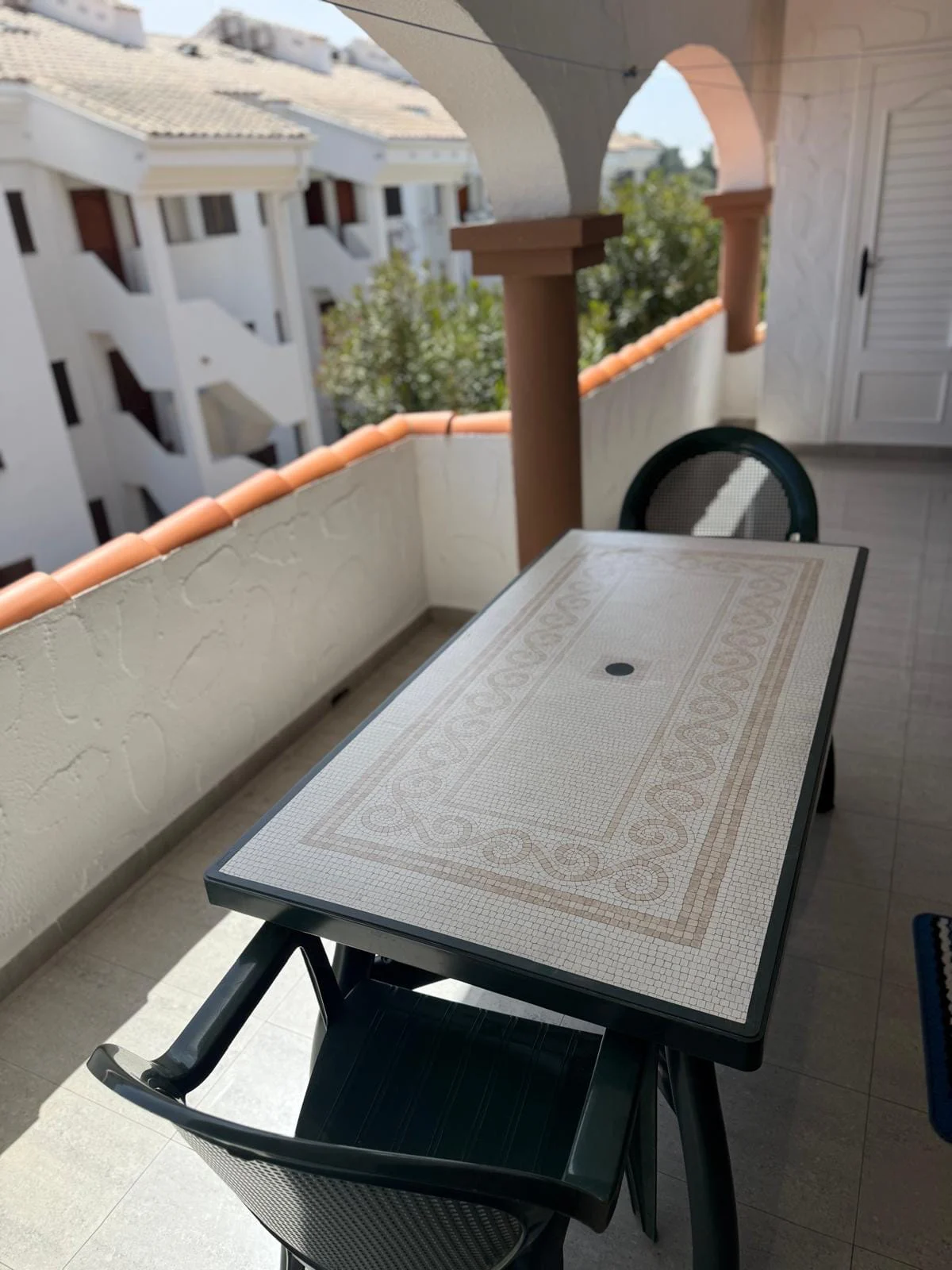 Terraza de Pascua IV con mesa, sillas y arcada