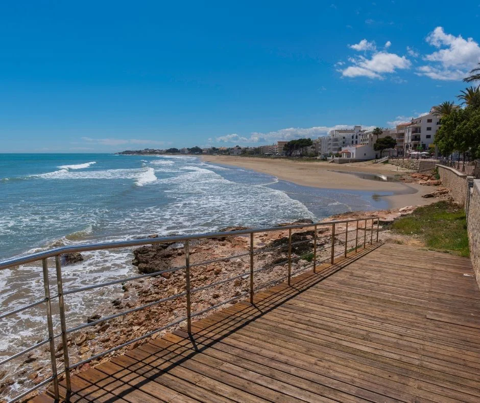 Pasarela junto a una playa de arena y roca en Alcossebre